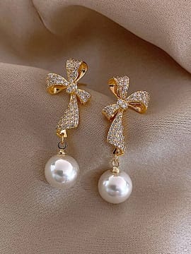 a pair of Rhinestone Bow Design Earrings with pearls and diamonds